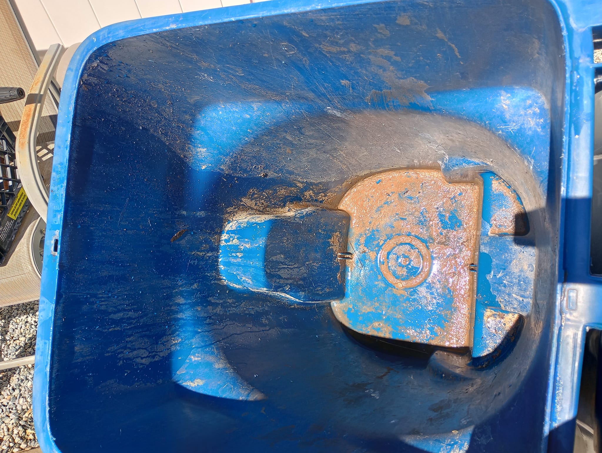 A dirty trash bin before cleaning in bullhead city Arizona. The built up brown grime can be seen stuck to the bottom of the trash can receptacle. 