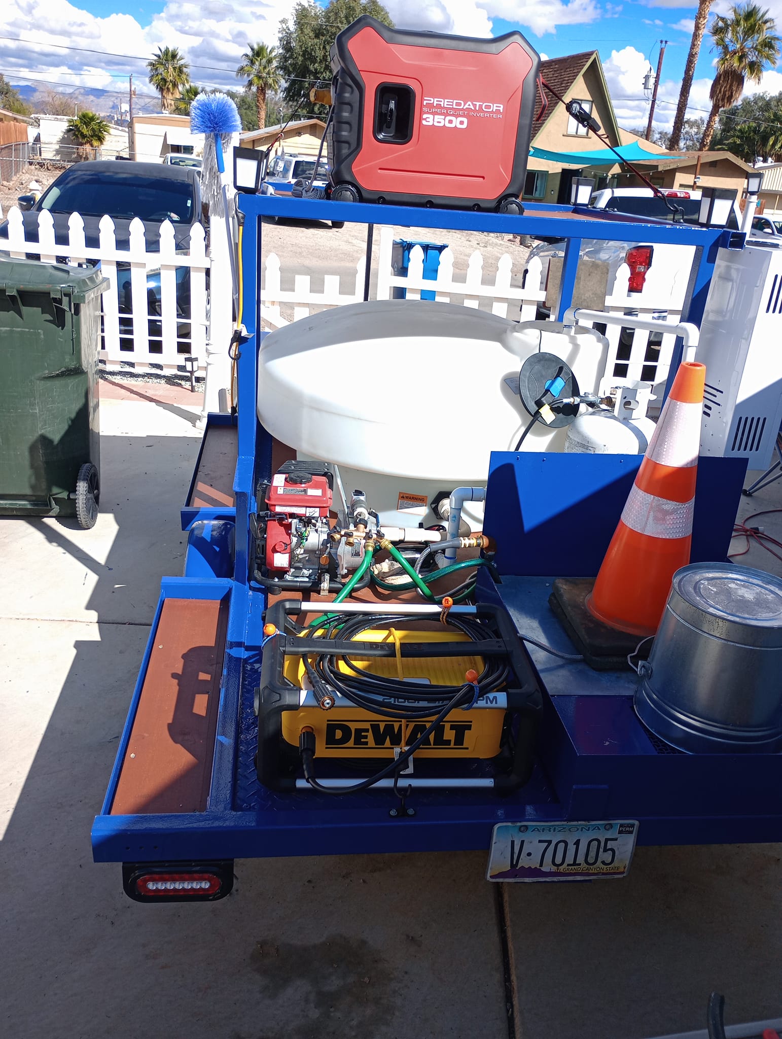 Our custom utility trailer loaded with various equipment including a generator, water tank, eco-friendly hot water power washing system, tools, and a traffic cone allowing a mobile trash bin cleaning service with zero mess left behind.